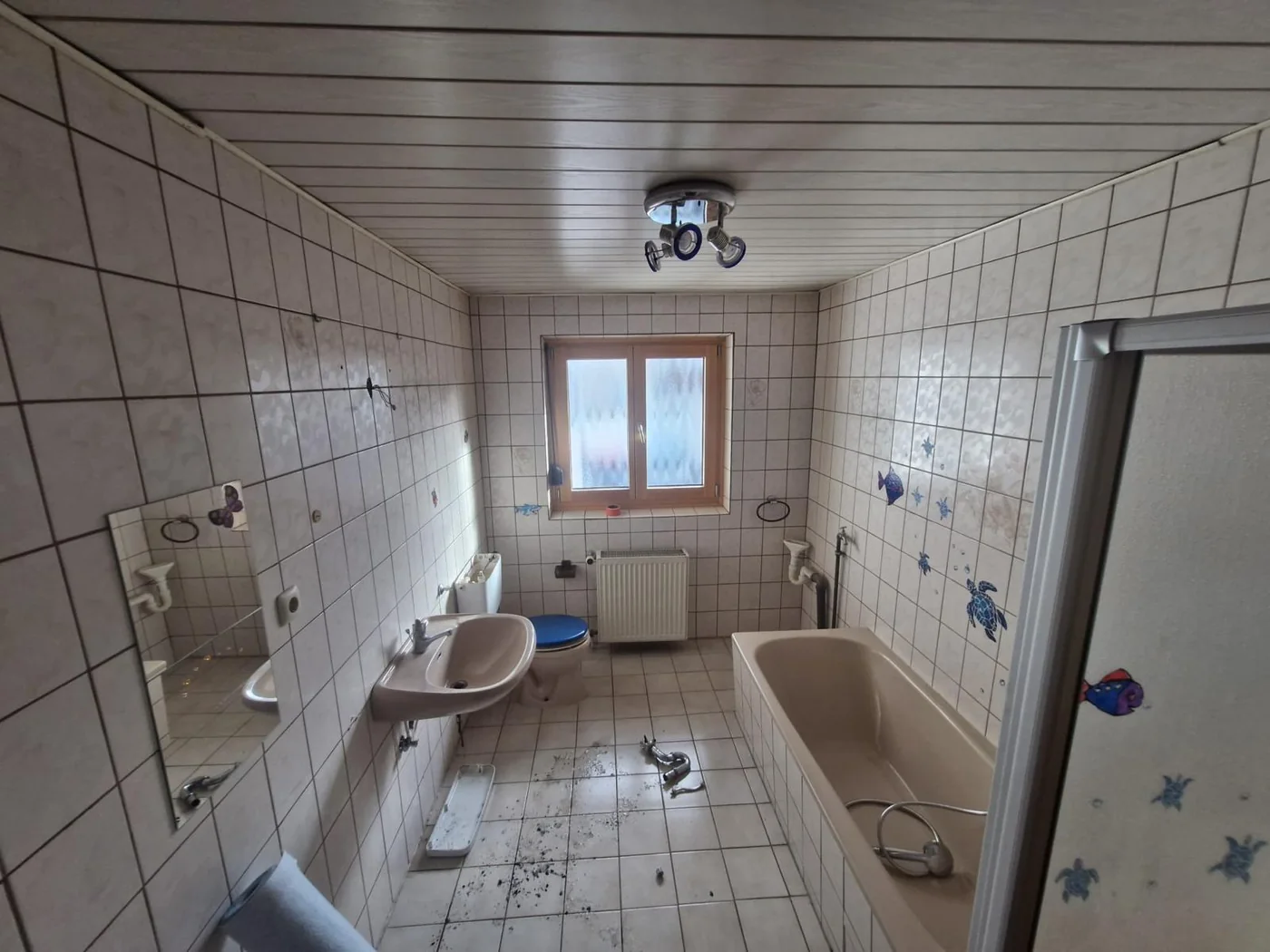 Badezimmer vor der Sanierung, alte Fliesen und Sanitärobjekte